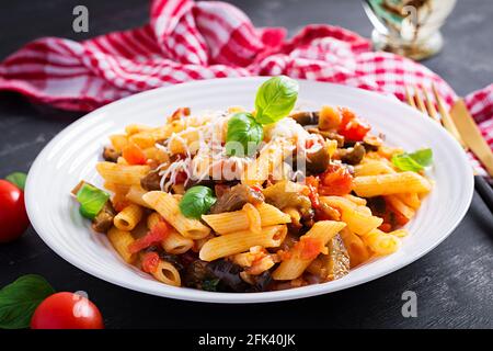Penne di pasta con melanzane. Pasta alla norma - cucina tradizionale italiana con melanzane, pomodoro, ricotta e basilico. Foto Stock