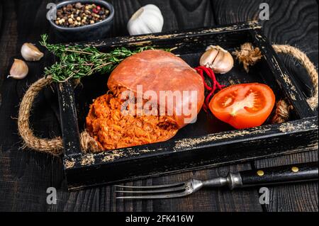 Mallorcan Sobrassada salumi di carne di maiale in un vassoio di legno sfondo di legno nero. Vista dall'alto Foto Stock