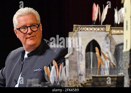 Erfurt, Germania. 28 Apr 2021. Guy Montavon, direttore generale del Teatro Erfurt, siede sul palco del teatro durante una conferenza stampa per il Domstufen Festival e guarda un modello del palcoscenico design. Dal 9 luglio al 1 agosto, il Teatro Erfurt prevede di esibirsi presso il Domstufen Festival di Tchaikovsky "la Maid of Orleans". Credit: Martin Schutt/dpa-Zentralbild/dpa/Alamy Live News Foto Stock