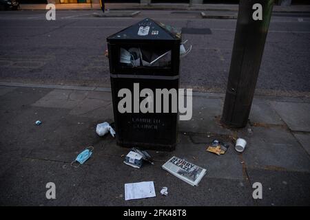 Londra, Regno Unito. 27 Apr 2021. Bidone dei rifiuti sovraccaricato con scatole per pranzo, maschere facciali e un giornale con le ultime accuse finanziarie contro i conservatori nel centro di Londra, mentre le restrizioni di Coronavirus iniziano a sciagarsi e l'economia inizia a riprendersi a Londra, in Inghilterra, il 27 aprile 2021. Il primo ministro Boris Johnson ha definito una tabella di marcia per allentare le restrizioni. Credit: Sipa USA/Alamy Live News Foto Stock