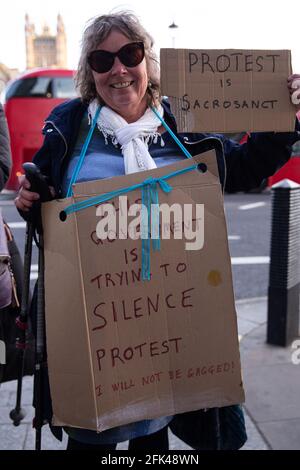 Una donna si erge con un banner che sostiene il diritto di protesta civile di fronte a Westminster, Londra, Inghilterra, il 26 aprile 2021. Foto Stock