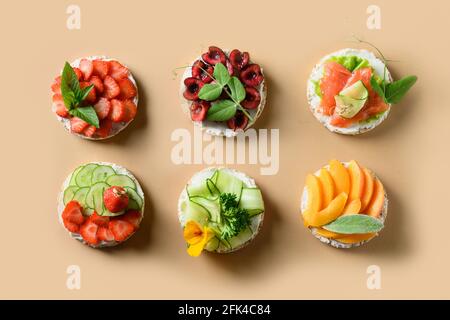 Torte di riso guarnire frutta, verdura e frutti di bosco su sfondo beige di colore. Cibo vegano sano e colorato e spuntino estivo. Gustoso antipasto estivo. FLA Foto Stock