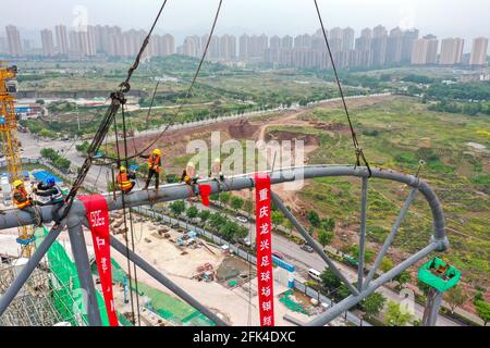 Chongqing. 28 Apr 2021. In questa foto aerea scattata il 28 aprile 2021, i lavoratori sono occupati nel cantiere del campo di calcio di Chongqing Longxing nel comune di Chongqing, nella Cina sudoccidentale, . La costruzione della struttura principale del campo di calcio di Chongqing Longxing è stata completata mercoledì. Una volta completato, il campo di calcio Longxing, come sede della Coppa asiatica AFC 2023, sarà in grado di ospitare 60,000 persone per guardare la partita. Credit: Huang Wei/Xinhua/Alamy Live News Foto Stock