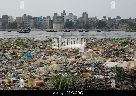 Dhaka, Bangladesh. 28 Apr 2021. Rifiuti di plastica sulle rive come la gente attraversa in barca sopra il campo acqua nera del fiume Buriganga in Dhaka. Milioni di metri cubi di rifiuti tossici provenienti dalle concerie e migliaia di altre industrie, con un enorme volume di acque reflue non trattate provenienti dalla città di Dhaka, hanno causato l'inquinamento idrico nei fiumi per raggiungere livelli allarmanti. Credit: SOPA Images Limited/Alamy Live News Foto Stock