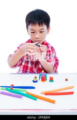 Piccolo ragazzo asiatico che gioca e crea giocattoli dall'impasto da gioco. Bambino che modella balena modellando l'argilla, su sfondo bianco. Rafforzare l'immaginazione di chi Foto Stock