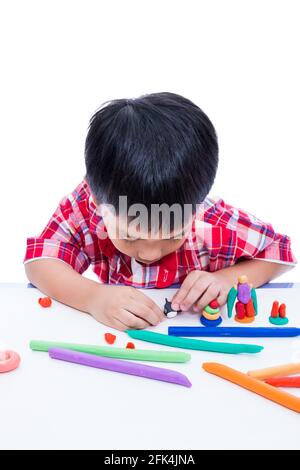 Piccolo ragazzo asiatico che gioca e crea giocattoli dall'impasto da gioco. Bambino che modella balena modellando l'argilla, su sfondo bianco. Rafforzare l'immaginazione di chi Foto Stock