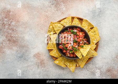 Salsa di pomodoro tradizionale messicana con nachos e ingredienti pomodori, cile, aglio, cipolla su sfondo di pietra ardesia chiaro. Concetto di latino em Foto Stock