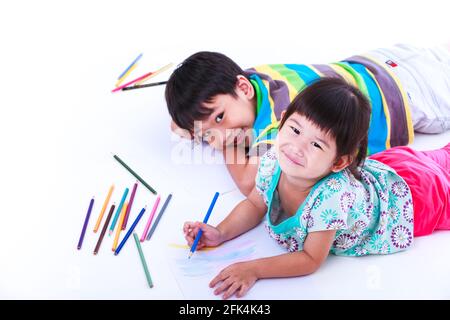 Asian (thai) sibling felicemente, fratello e sorella guardando la macchina fotografica e sorridendo, su sfondo bianco. Concetti di creatività ed educazione, forza Foto Stock