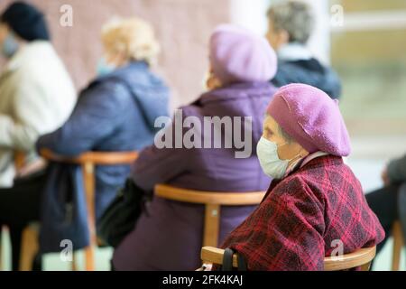 Bielorussia, la città di Gomil, 17 aprile 2021 Meeting Club degli anziani. Un uomo anziano in una maschera medica, sparato in profilo. I posti a sedere degli anziani a un Foto Stock