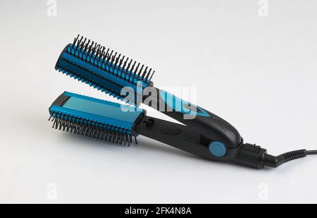 Piastra per capelli blu con pettine isolato su sfondo bianco Foto Stock