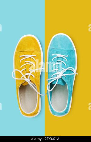 Nuove scarpe da passeggio in pelle scamosciata gialla e blu su sfondo giallo e blu. Vista dall'alto. Foto Stock