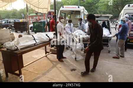 Nuova Delhi, India. 28 Apr 2021. (NOTA PER I REDATTORI: Immagine della morte) l'operaio sanitario e i membri della famiglia portano un corpo del loro parente che è morto dal virus Coronavirus Covid-19 per la cremazione a un crematorio. L'India si trova ad affrontare il numero di casi di Covid-19 in più rapida crescita al mondo, con 360,927 nuove infezioni confermate, il numero più alto di giorni nel paese e più di 3,293 decessi nel mese di aprile 2021. Credit: SOPA Images Limited/Alamy Live News Foto Stock