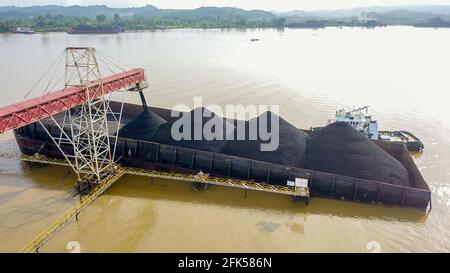 Trasporto del carbone in indonesia, caricando il carbone sulla vista aerea della chiatta Foto Stock