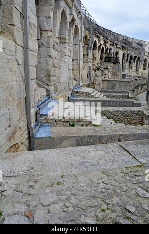 All'interno di un antico anfiteatro romano a Nimes, nel sud della Francia, con alti corridoi ad arco che portano ai posti a sedere. Una delle anfite meglio conservate Foto Stock