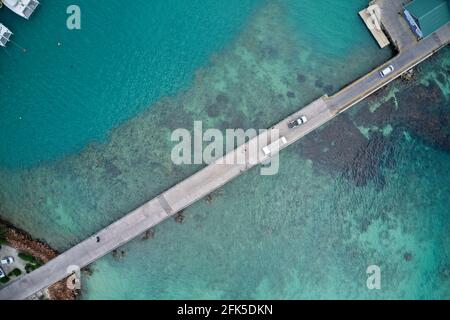 Drone campo di vista della strada che attraversa acque turchesi blu al porto di Praslin, Seychelles. Foto Stock