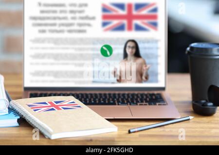 Libro di testo inglese e matita che giace sul tavolo vicino laptop closeup Foto Stock