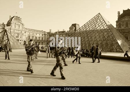 PARIGI, FRANCIA - 12 MARZO 2016: I soldati pattugliano vicino al museo del Louvre. La Francia ha rafforzato le misure di lotta contro la criminalità e il terrorismo. Foto Seppia Foto Stock