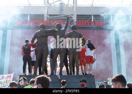 Protesta contro Glazer al campo di football Old Trafford . Il sostenitore si trovava sulla statua della Trinità circondata dal fumo. Stadio Manchester United, Regno Unito Foto Stock