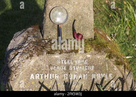 Lente d'ingrandimento e tubo sulla tomba di Sir Arthur Conan Doyle in All Saints Churchyard, Minstead, New Forest District, Hampshire, Inghilterra Foto Stock