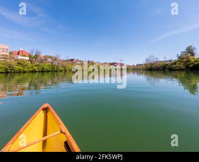 Uomo caucasico che va in canoa in un pacchetto sulla Monongahela fiume verso Morgantown e l'università della Virginia occidentale Foto Stock