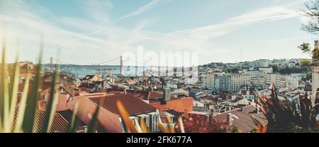 Foto panoramica di un paesaggio urbano di Lisbona soleggiato dall'alto; il panorama del paesaggio urbano di Lisbona con molte case antiche e moderne e un Foto Stock