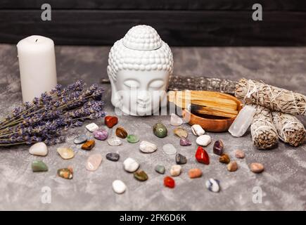 Meditazione rituale spirituale volto di Buddha, candele su sfondo grigio Foto Stock