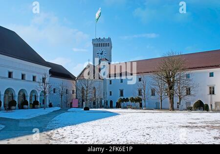 Il cortile innevato del Castello di Lubiana (Ljubljanski Grad) con gli edifici storici della Cappella di San Giorgio e la Torre panoramica, Slovenia Foto Stock