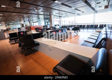 Amburgo, Germania. 27 Apr 2021. I posti a sedere vuoti, alcuni dei quali bloccati, possono essere visti nell'area delle partenze del Terminal 1 dell'aeroporto di Amburgo. Solo circa il dieci per cento dei passeggeri abituali è attualmente a bordo di un aereo nella città anseatica. L'aeroporto è stato certificato dall'associazione internazionale Aereoporti Council International per quanto riguarda lo standard delle sue misure di protezione e igiene corona. (Al dpa 'Aeroporto di Amburgo: Terminal vuoto, certificato Corona e routine') credito: Christian Charisius/dpa/Alamy Live News Foto Stock