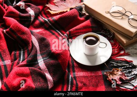 Bella composizione autunnale con tazza di caffè e libri su plaid Foto Stock