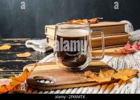 Bella composizione autunnale con tazza di caffè e libri su sfondo di legno scuro Foto Stock