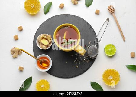 Composizione con una tazza di gustoso tè allo zenzero e ingredienti sfondo bianco Foto Stock
