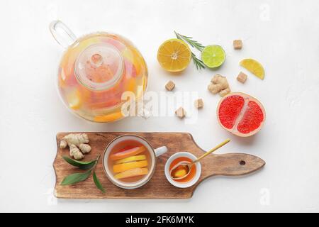 Composizione con gustoso tè allo zenzero e ingredienti su sfondo bianco Foto Stock