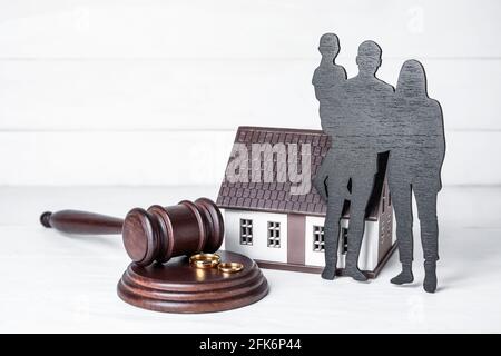 Figure di famiglia con il gavel del giudice e gli anelli sulla luce sfondo di legno Foto Stock