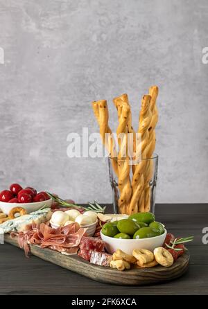 Antipasti a bordo con diversi antipasti italiani, formaggi, salumi e cracker Foto Stock