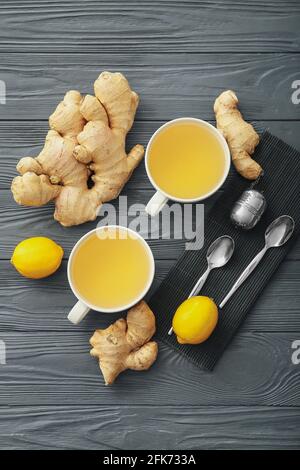 Tazze di tè con zenzero e limoni su legno scuro sfondo Foto Stock