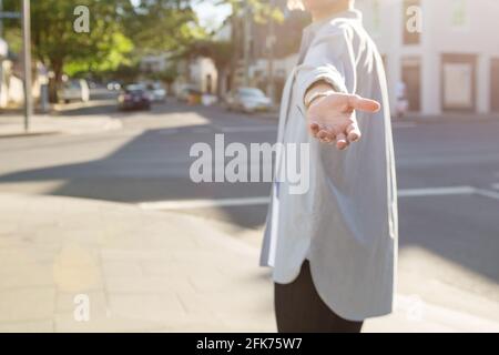 donna che torna indietro con mano fuori Foto Stock