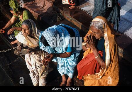 13.03.2010, Haridwar, Uttarakhand, India, Asia - i pellegrini vestiti con abiti colorati e tradizionali pregano al Ghat Har Ki Pauri sul fiume Gange. Foto Stock