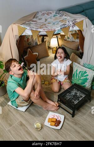 Ragazzo e ragazza che si divertono a mangiare marshmallows Foto Stock