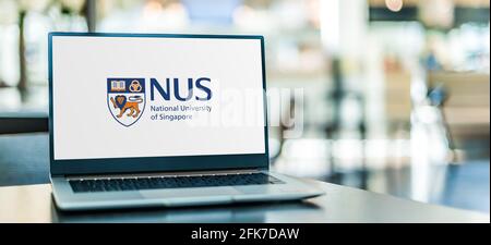 POZNAN, POL - Apr 20, 2021: Computer portatile con logo della National University of Singapore (NUS), l'università nazionale di ricerca di Singapo Foto Stock
