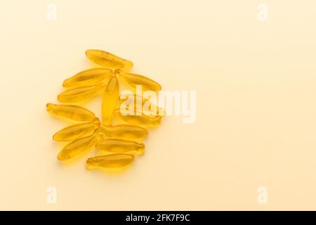 Capsule di supplemento di olio di pesce omega-3 isolate su superficie gialla. Concetto di assistenza sanitaria Foto Stock