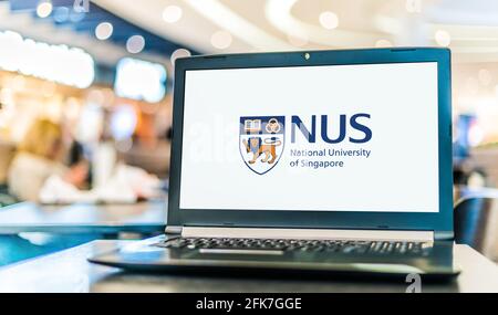 POZNAN, POL - Apr 20, 2021: Computer portatile con logo della National University of Singapore (NUS), l'università nazionale di ricerca di Singapo Foto Stock