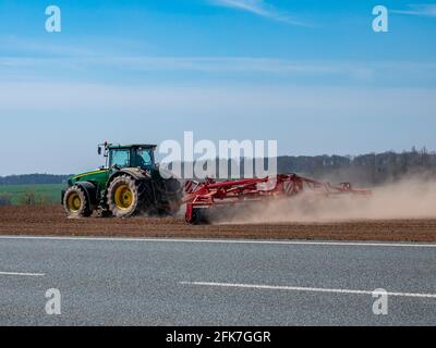 Trattore che aratura un campo in molla Foto Stock