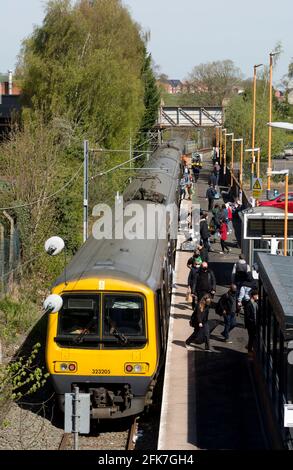 Persone che scatteranno da un treno elettrico della West Midlands Railway alla stazione di Redditch, indossando coperture per il viso durante la pandemia di Covid-19, Worcestershire, Regno Unito. Foto Stock