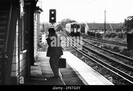 Stazioni ferroviarie Clapham Junction un uomo parla sul suo cellulare il telefono come un treno pendolari adopra la piattaforma dbase Foto Stock
