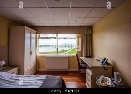 Letto confortevole e armadio in stile minimalista situato vicino alla  finestra con tende nella camera da letto moderna Foto stock - Alamy