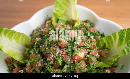 Una ciotola di deliziosa insalata di Tabbouleh fresca con prezzemolo, menta, pomodoro, cipolla, olio d'oliva e succo di limone.Tabbouleh (tabbouli) Foto Stock