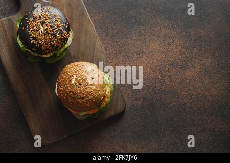 Hamburger di vegan alla moda con polpette di verdure come carne a base di piante su fondo marrone darl. Spazio di copia. Vista dall'alto. Foto Stock