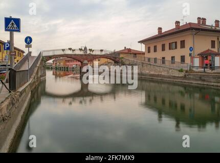 Ponte e casali colorati sull'antico canale chiamato Naviglio Grande nella campagna vicino a Milano.Lombardia,Italia. Foto Stock