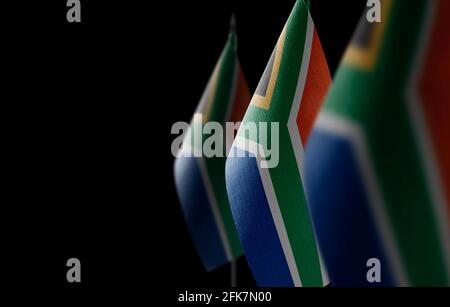 Piccole bandiere nazionali del Sudafrica su un nero sfondo Foto Stock