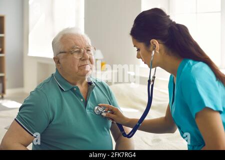 Giovane infermiera ispanica femminile controllare il battito cardiaco maturo del paziente caucasico primo piano Foto Stock